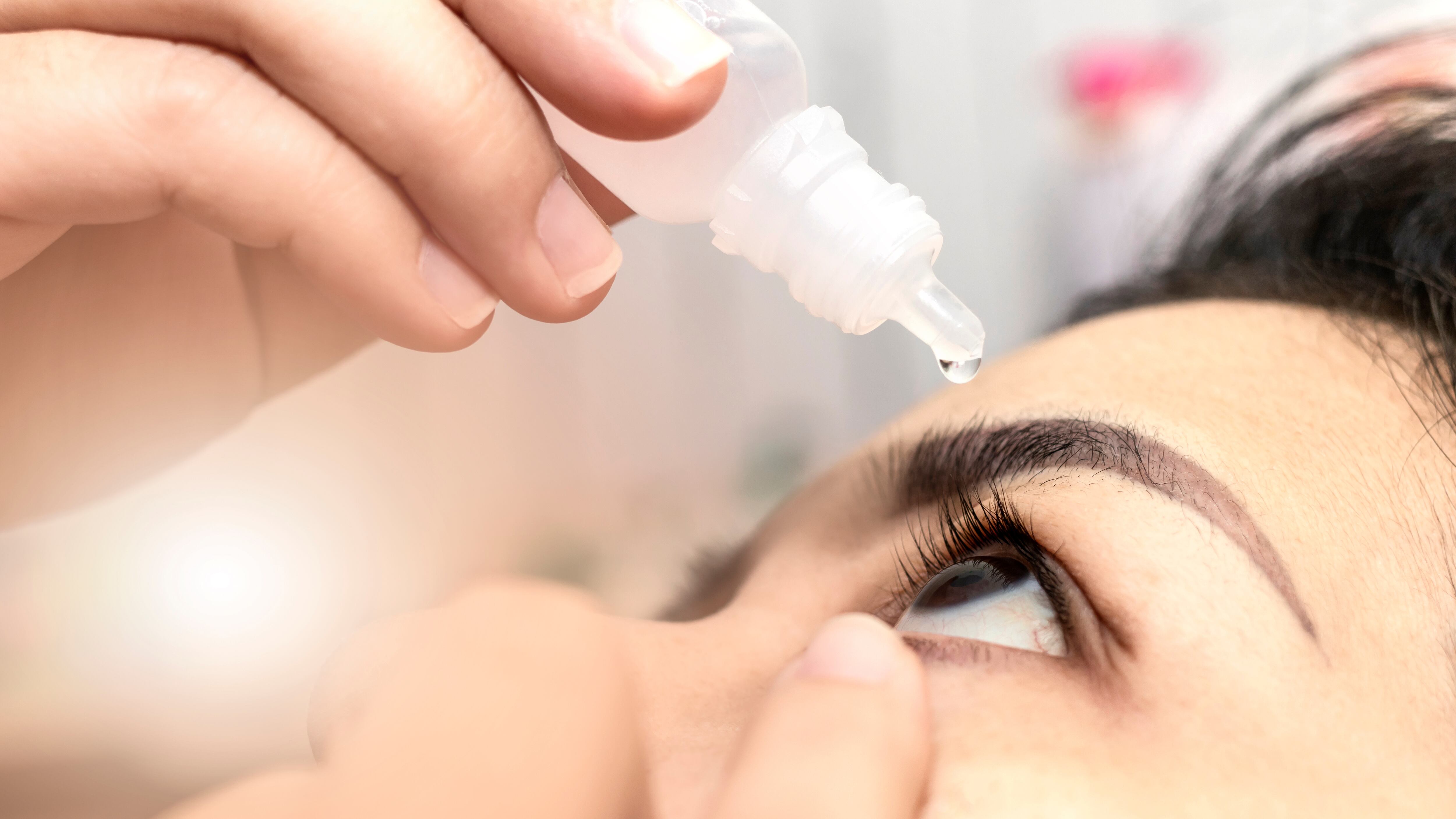 Woman using eye drops